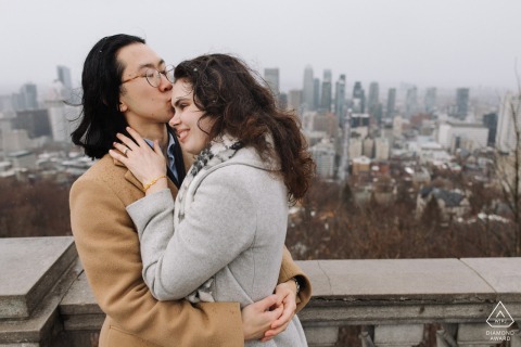 At Belvedere Kondiaronk in Montreal, Canada, a couple embraces in the rain while overlooking the city. This romantic scene is beautifully captured by a talented WPJA photographer.