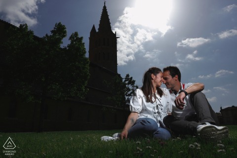 In the charming village of Saint Sulpice sur Lèze, France, a couple sits on the grass with the low sun behind them, creating an inviting scene captured by a talented WPJA photographer.