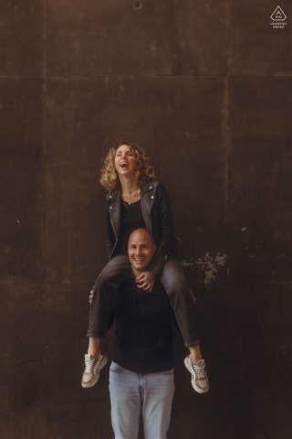 In Vierzon, a playful scene of the groom to be joyfully carrying the bride to be on their shoulders unfolds.