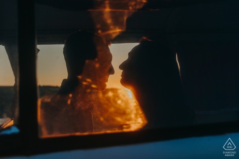 A silhouetted couple embraces at sunset in Bannay, surrounded by warm, glowing skies, highlighting their romantic engagement.