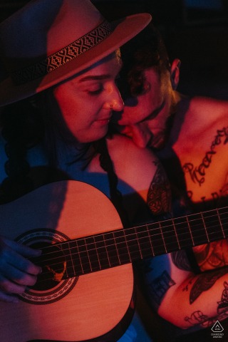 In Saint Satur, the bride to be plays the guitar for her groom, seated together outdoors, enveloped in a romantic and serene atmosphere.