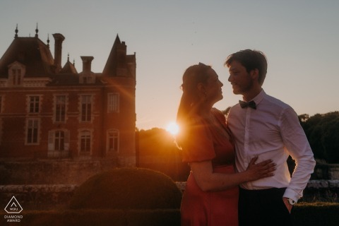 At Chateau de la Bussiere, a couple embraces lovingly in front of the historic backdrop, epitomizing timeless romance.