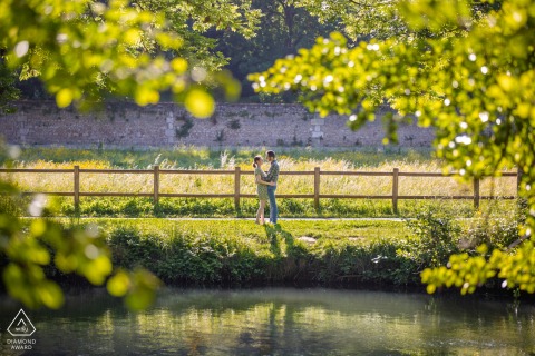 An engaged couple poses lovingly in front of a rustic wooden fence in Poitiers, exuding warmth and charm.