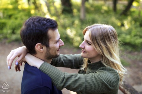 Sharing a Loving Gaze: Vecsés Couple Embraces Surrounded by Nature’s Lush Greenery A couple from Vecsés shares a loving gaze, surrounded by lush greenery, creating an intimate portrait in nature.