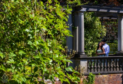 A couple on a bridge in Hampstead Heath, London, framed from a distance. Off-center composition enhances their presence.