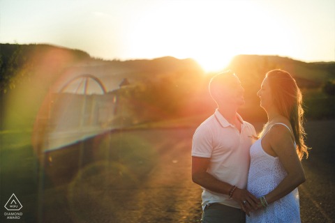 In Ternand, Beaujolais, France, the couple smiles as golden light surrounds them, with lens flares enhancing their warm connection.