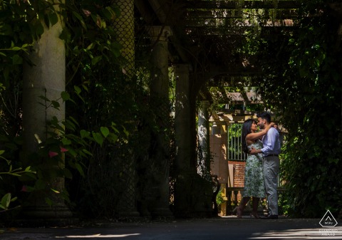 Engaged couple poses in Hampstead Heath, London, surrounded by nature with a soft depth of field.