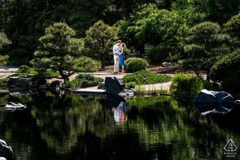 Smiling couple poses peacefully in tranquil Japanese Garden at Denver Botanic Gardens, lush greenery surrounds.