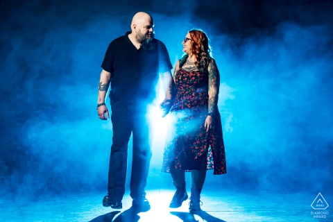 Couple in Denver, CO, USA, walking hand in hand through dramatic scene with swirling smoke and striking blue light effects.