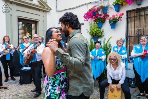 Pre-wedding couple dances joyfully in Córdoba, Spain, as a band plays nearby;  musicians dressed in matching blue.