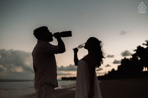 As the sun dips below the horizon at Praia de Ipioca, a couple silhouettes against the vibrant sky, toasting to their future. This enchanting pre-wedding engagement portrait, crafted by a talented WPJA photographer, captures their love.