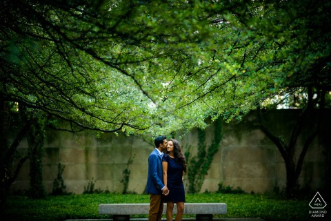 Couple embraces underneath lush tree canopy during their engagement session at Chicago’s Art Institute South Garden.