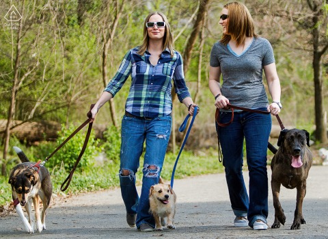 Couple walks their dogs together through Piedmont Park, Atlanta, surrounded by greenery and open space.