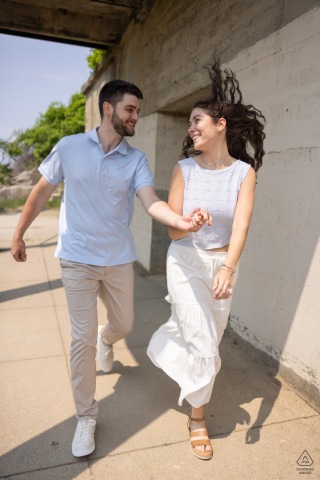 Couple running and laughing together near Portland Headlight lighthouse