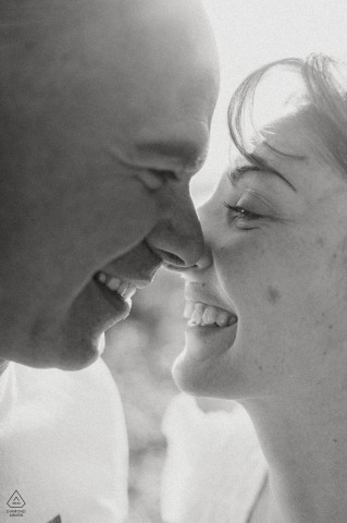 Engaged couple share a tender look, embracing closely, radiating love and complicity in romantic portrait.