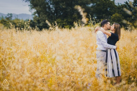 Engaged couple in Ceparana, surrounded by tall grasses, sharing a natural, loving embrace.