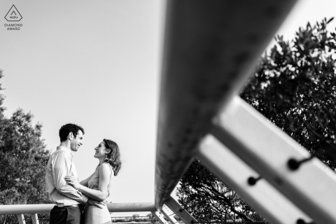 Engaged couple smiles, embracing at Kennedy Center in Washington DC.