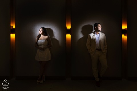 Dramatic, symmetric portrait of couple framed by lobby wall and lights at AC Marriott San José.
