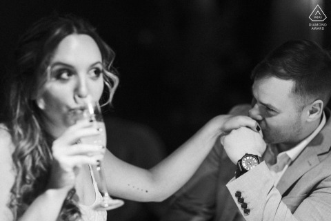 Engaged couple enjoys drinks in dimly lit Whiskey Bar and Grill, Cleveland, creating an enticing atmosphere. 