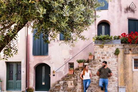 Couple leans against beautiful wall in Grado, Italy, lovingly gazing into each other's eyes.