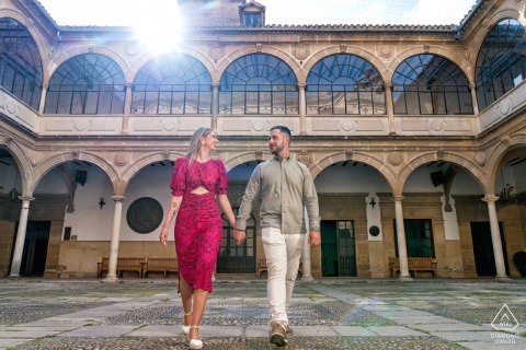 Engaged couple holding hands, walking through old building courtyard, pre-wedding portrait, Baeza, Jaén, Spain.