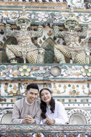 Couple posing for an engagement portrait at an ornate ancient building in Bangkok, Thailand.