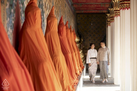 Engagement portrait of a couple walking in the corridors of a temple in Bangkok, Thailand.