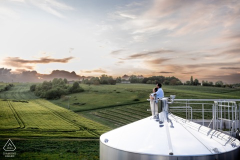 Engagement portrait of a couple on Cognac cisterns at Vignoble du Cognaçais, France.