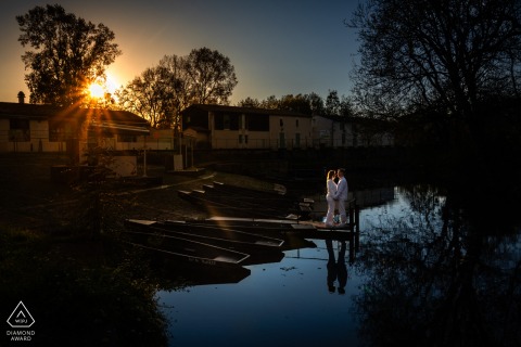Engagement photo in Marais Poitevin, France, with a couple standing on the dock.