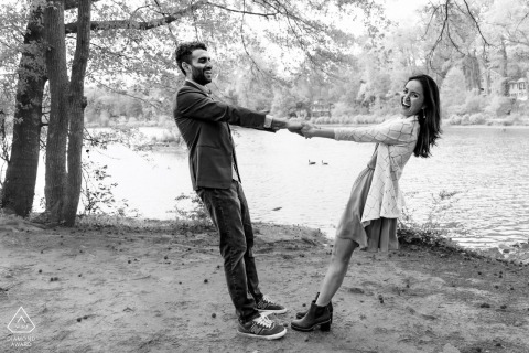 PINE LAKE, Ga. — A couple stands together, holding hands and leaning back playfully under a canopy of trees. They share a quiet, supportive closeness by the water's edge.