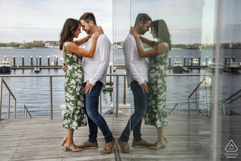 BOSTON — The reflection of a couple embracing is captured in glass, with the Seaport District’s modern architecture and waterfront serving as a striking backdrop for their engagement portrait.