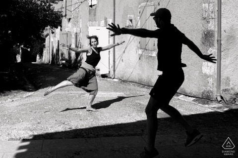 LECTOURE, France — This engagement portrait captures a couple's playful dance at The Castelnau, with the groom-to-be silhouetted against his future bride, who is bathed in sunlight.
