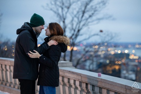 MONTREAL — An engaged couple embraces at dawn atop Mount Royal, their love warming the cold air as they stand face-to-face, overlooking the panoramic cityscape in this winter portrait.