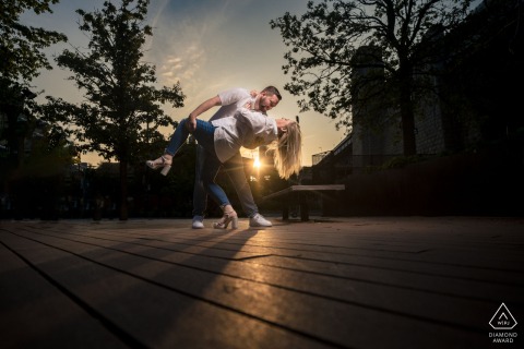 PHILADELPHIA — The couple strike a romantic dip pose at the scenic Race Street Pier. This engagement portrait, bathed in light, captures their love.
