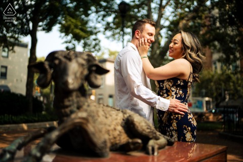 Sunlit Engagement Portraits in Philadelphia: A Gentle Touch and Pure Admiration PHILADELPHIA — Under a canopy of sunlit trees, a woman gently touches her fiancé's face as they gaze at each other with pure admiration during their engagement portrait session.