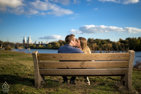PHILADELPHIA — A couple shares a quiet embrace on a park bench overlooking the river, their gentle kiss capturing the serene connection and deep affection of their love.