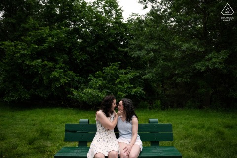 BOSTON — A couple sits closely on a park bench at Christian Herter Park, their joyful connection highlighted by the lush, green backdrop..