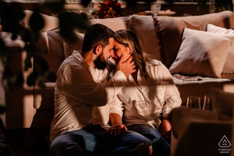 Engaged couple at Vale dos Ventos, Rio dos Cedros, SC: relaxing in a cabin, enjoying wine and intimate time together.