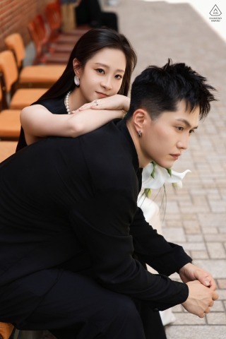 The Bund, Shanghai, China — She leans on him with a row of orange chairs in the background, creating a romantic and intimate atmosphere in this city portrait.