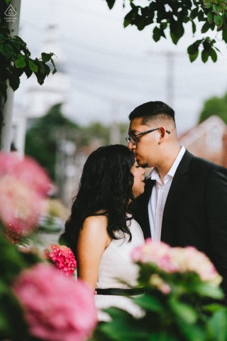 Downtown Annapolis, Maryland — A couple embraces in front of vibrant flowers, for a romantic and colorful engagement portrait in the heart of downtown.