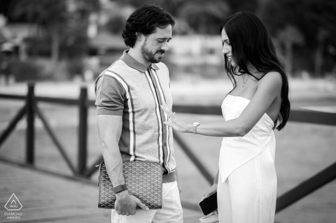 On Marbella Club Pier, a bride-to-be admires her engagement ring in a black and white portrait. She stands thoughtfully, the focus on her hand, capturing the excitement of the occasion.