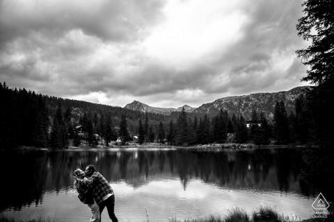 Timeless Black And White Kiss: Couple By Serene Lake In La Morte, France In La Morte, France, a couple shares a kiss in front of a serene lake. The black and white portrait has a painterly quality, evoking a timeless atmosphere.