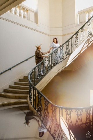 At Pasadena City Hall in California, a couple poses romantically on the grand stairs. The vertical portrait exudes glamour, with elegant architecture providing a sophisticated backdrop for their engagement session.