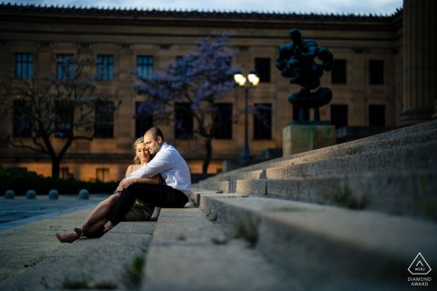 Intimate Portrait On The Philadelphia Museum Of Art Steps At the Philadelphia Museum of Art, a couple sits together on the steps, illuminated by off-camera lighting. Lost in each other, they transform the iconic location into an intimate world of their own.