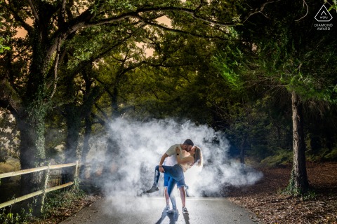 Pre-wedding portrait of a couple on a smoky forest path in Lugo, Galicia, Spain.