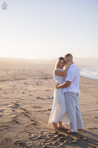 Wellfleet, Massachusetts engagement photography: Vertical shot of a couple in a deep embrace on Newcomb Hollow Beach. Romantic, candid Cape Cod portrait.