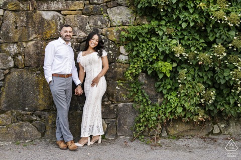 An intimate portrait of a couple set against a historic ivy-covered stone wall, captured within the serene, natural environment of the Arnold Arboretum in Massachusetts.