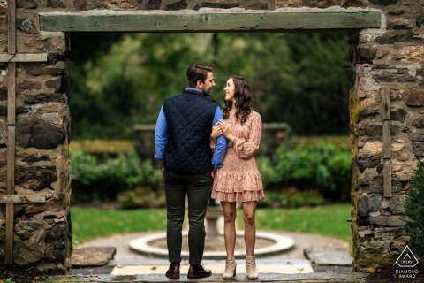 Ridley Creek Park: Facing Opposite, Turning Together, Holding On, Tenderly Connected An engaged couple in Parque Ridley Creek, Philadelphia. Though facing opposite ways, they turn to look at each other in a tender connection, as she gently holds his arms.