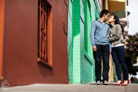 A candid city scene featuring an engaged couple on the pavement in San Francisco, CA. The low perspective puts the intimate focus on the couple.