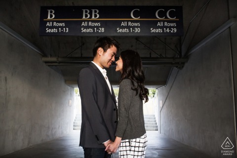 A tender portrait of a couple at UC Berkeley, captured sharing a soft, close embrace with their noses touching. The architectural tunnel provides a dramatic, sheltered space for their quiet display of affection.